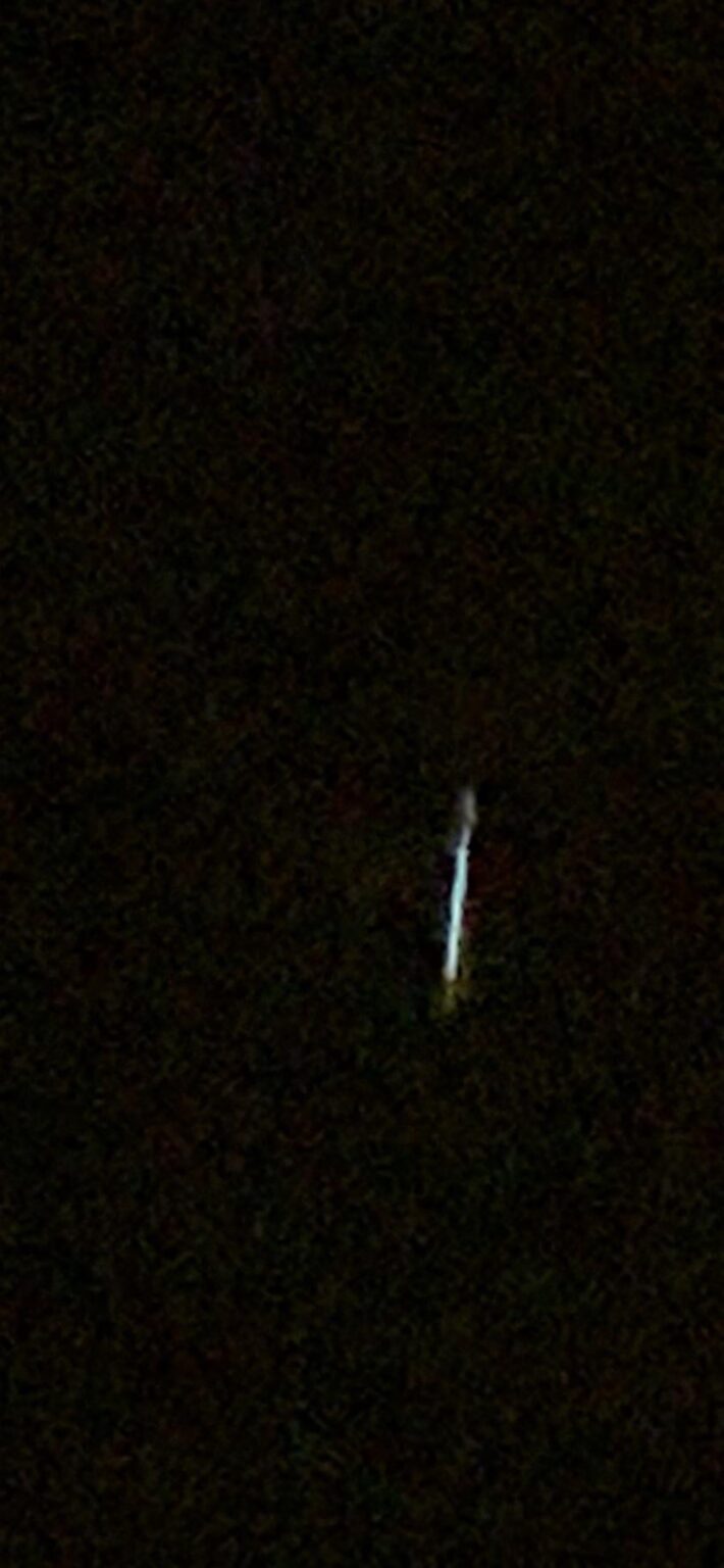 Solid bar of light like a portal or lightsaber in the sky.