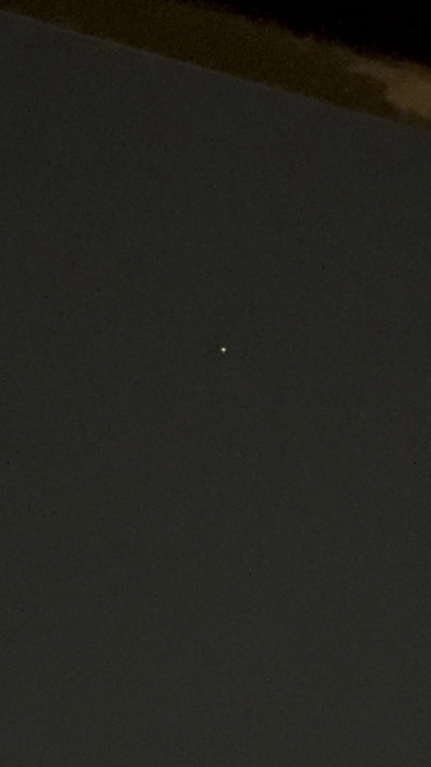 Colorful orb and cluster of lights beaming across the sky