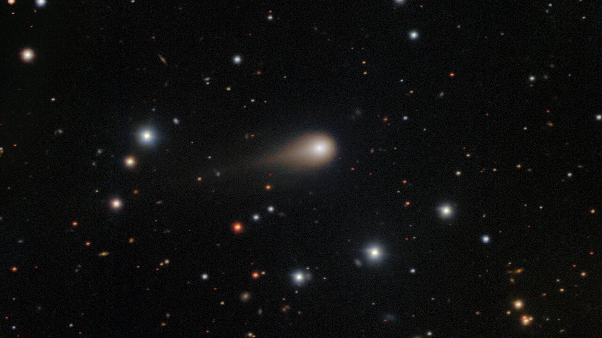 a photo of the comet 3I/ATLAS with its long tail shooting through space