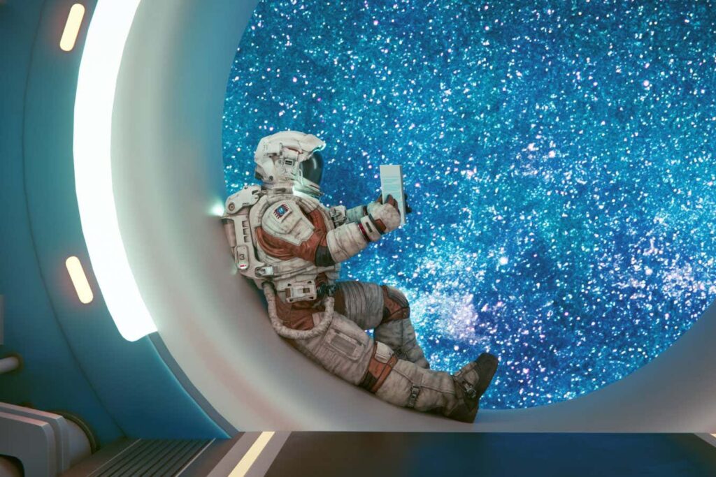 Astronaut sits in a window frame inside a space ship and reads a book about science. Concept of exploring space.