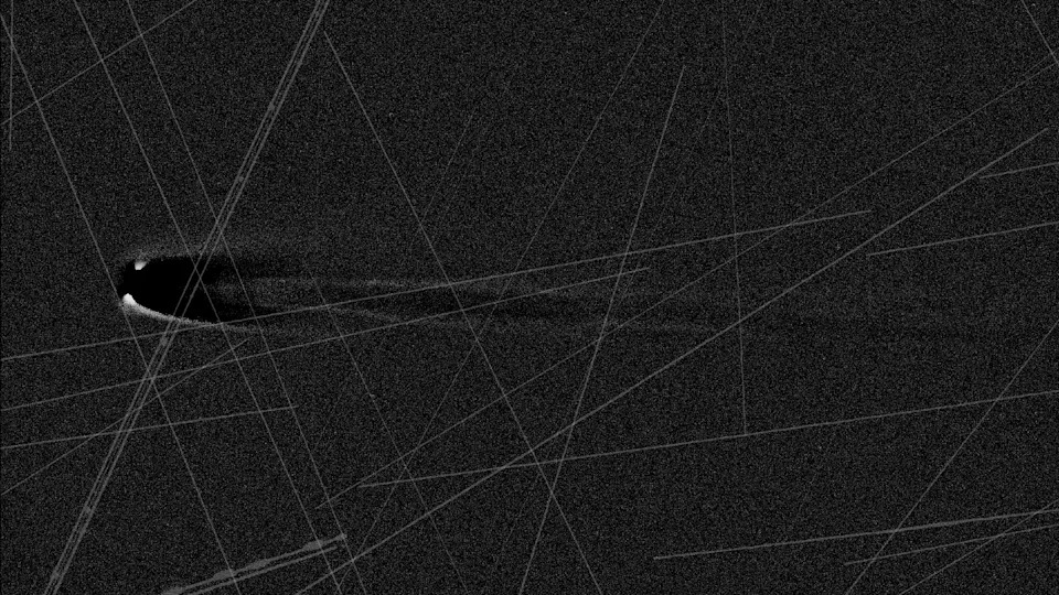 An image of a comet in black and white with lines streaking across the image. 