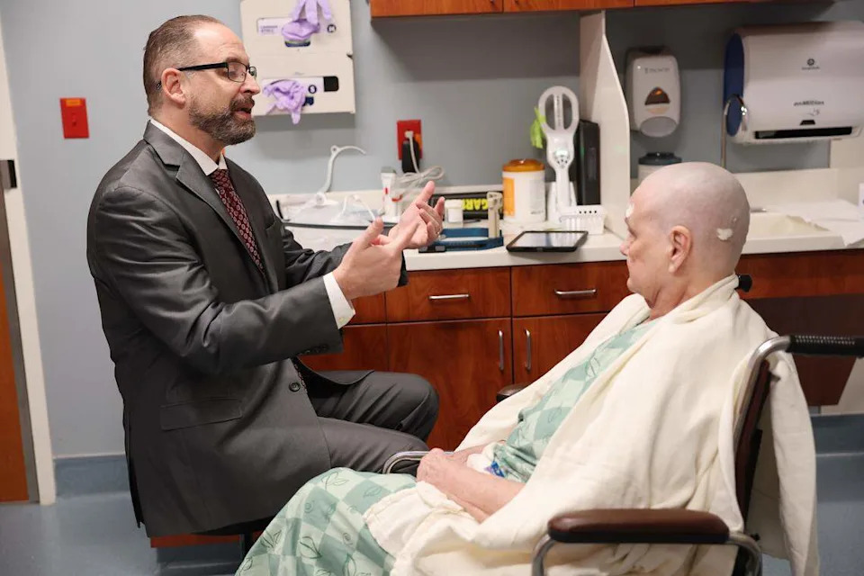 Neurosurgeon Dr. Charles Munyon goes over an incisionless brain procedure with patient Catherine Klie on Monday. 