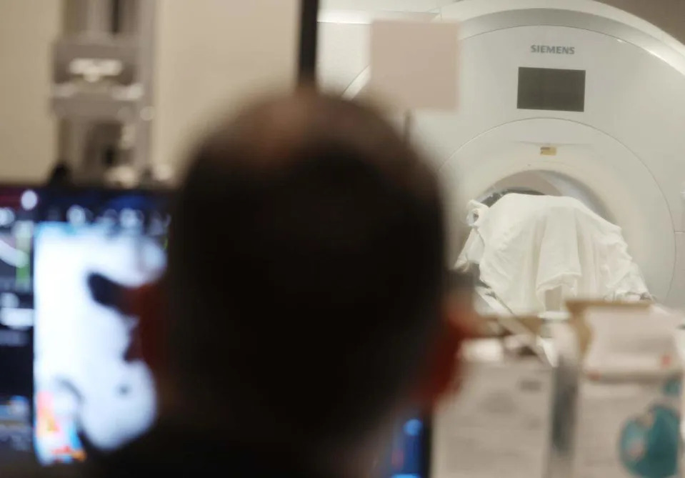 Neurosurgeon Dr. Charles Munyon works on a computer as patient Catherine Klie undergoes an incisionless brain procedure Monday in Mint Hill. 