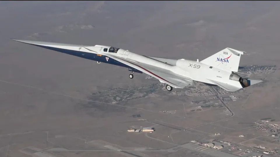 A small white plane flies above the desert