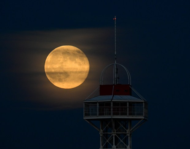 DENVER, CO - NOVEMBER 05: Super moon with a little cloud cover and the Elitches Observation Tower in the foreground photographed west of Empower Field at Mile High in Denver, Colorado on Wednesday, November 05, 2025. (Photo by Andy Cross/The Denver Post)