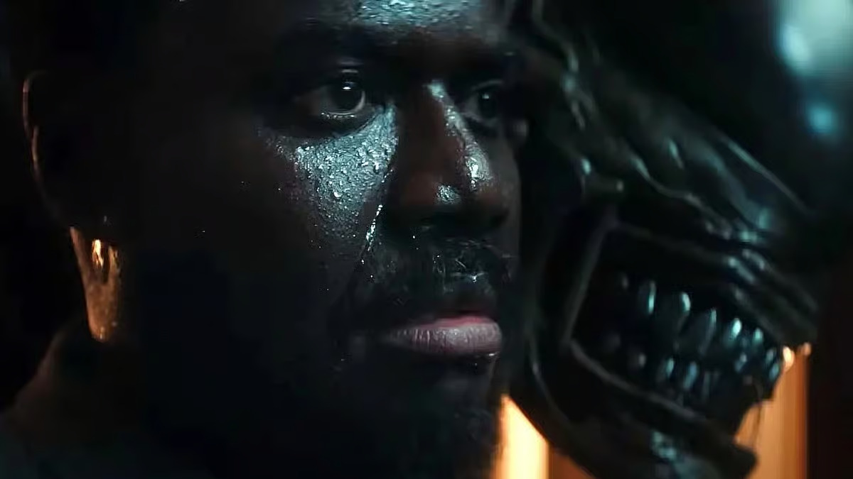 A close up of a sweating Morror as a Xenomorph appears behind him in Alien: Earth