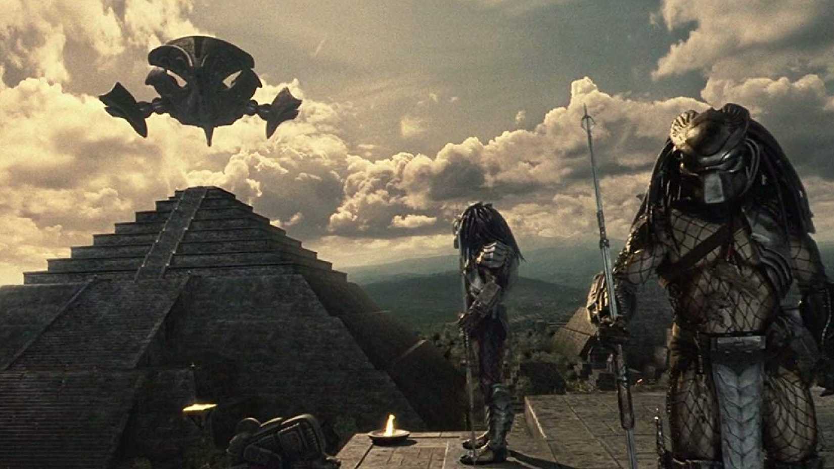 Predator aliens on top of a pyramid with a spaceship in the background in Alien vs Predator