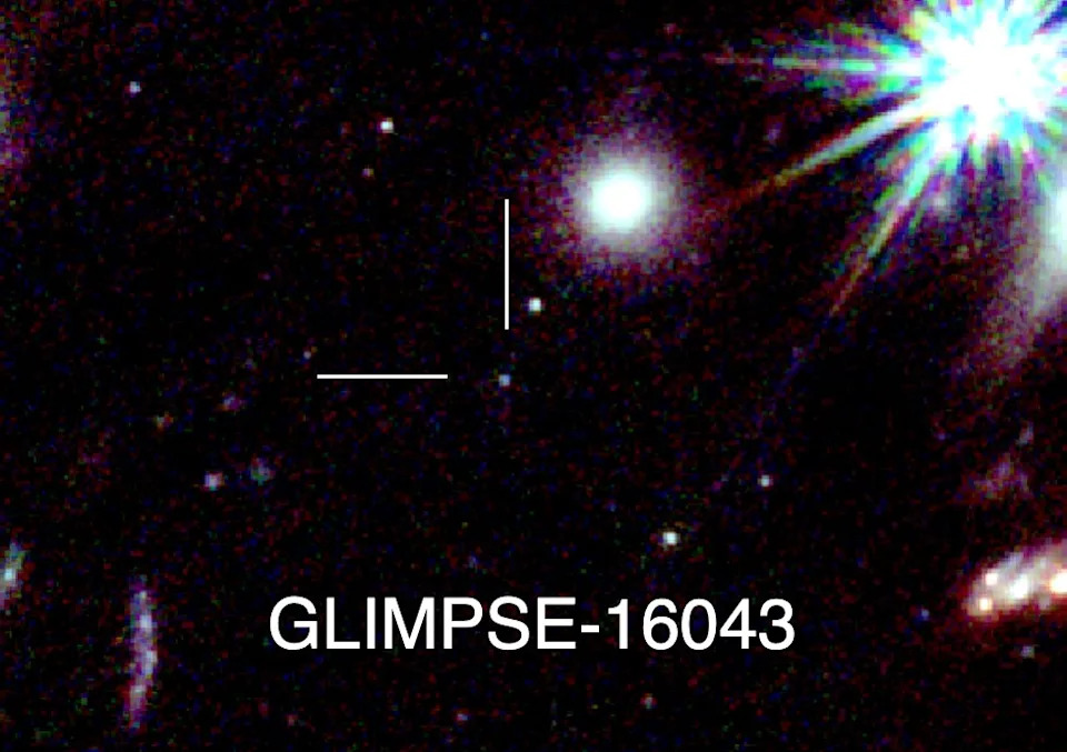 A tiny dot next to larger galaxies.