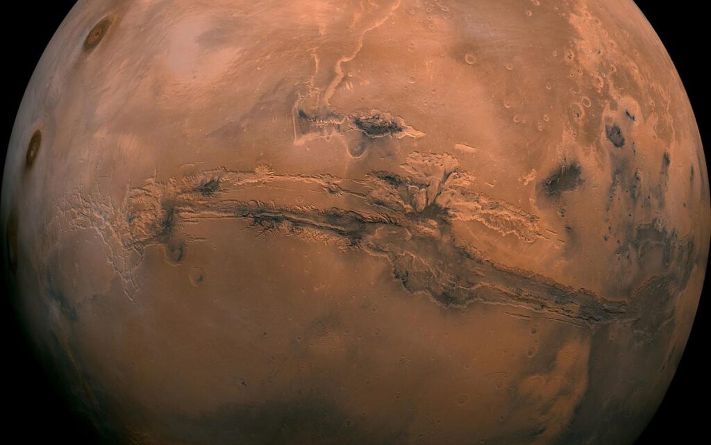 In the late 1800s alien ‘engineers’ altered our world forever A detailed NASA photo of Mars showing the Valles Marineris canyon system with cratered terrain and dust-streaked surface.