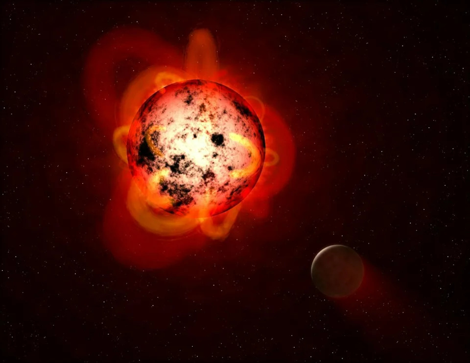 An illustration of a red dwarf star and a nearby planet