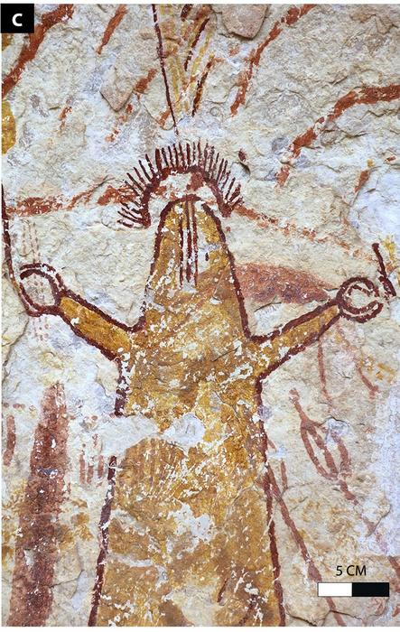 A rock painting of a figure with two outstretched hands and a halo shape over his head