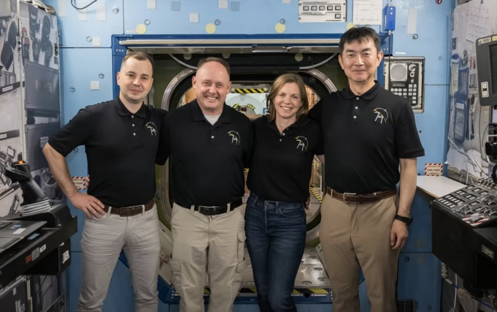 Crew-11 crew members posing for a photo inside a training mockup facility.