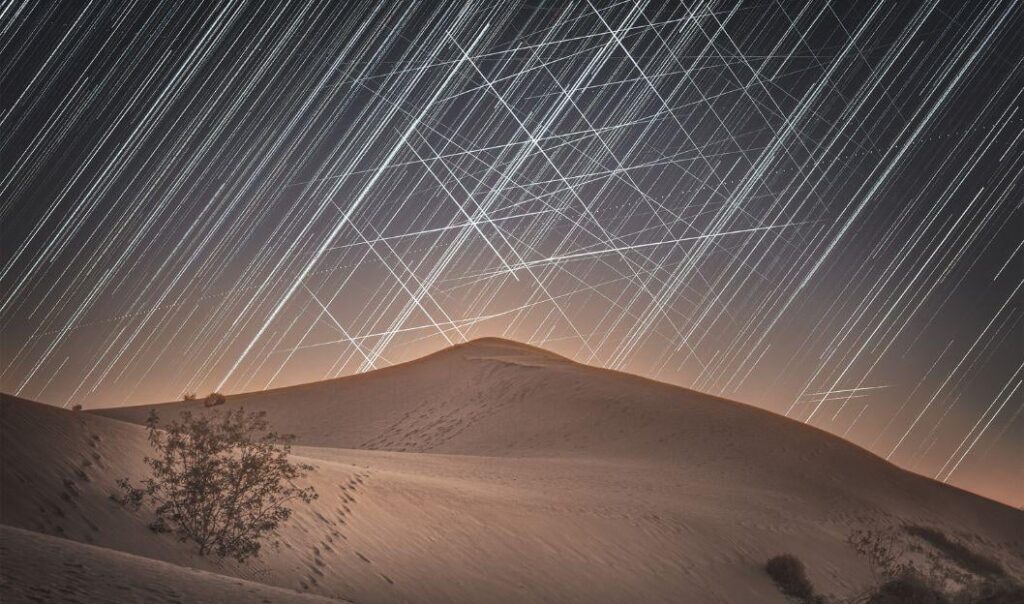 "Satellite Web Over Dunes" | Astrophotographer Lucy Yunxi Hu captured star trails and satellite streaks above Mungo National Park in Australia