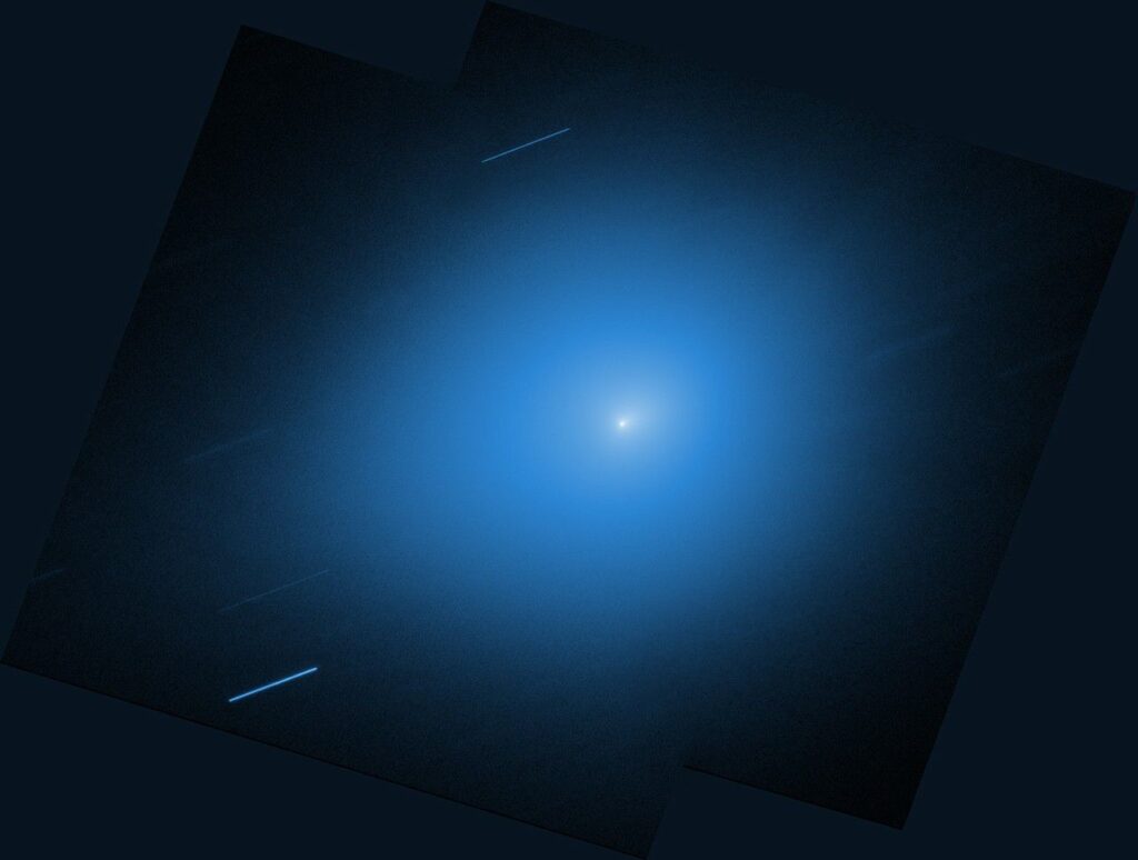 Interstellar comet 3I/ATLAS shines in new images ahead of close pass by Earth An image from NASA’s Hubble Space Telescope showing the interstellar comet 3I/ATLAS. The comet is a small white dot in the center of the image, with a light blue halo of light that takes up most of the image. Other stars are shown streaking across the image as diagonal blue-white lines.