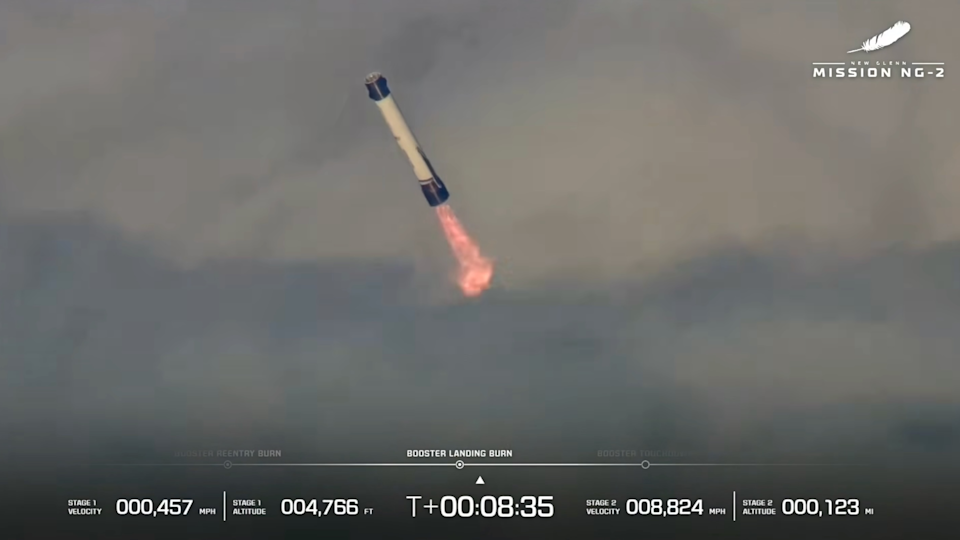 a large white-and-blue rocket fires its engines as it descends through clouds 
