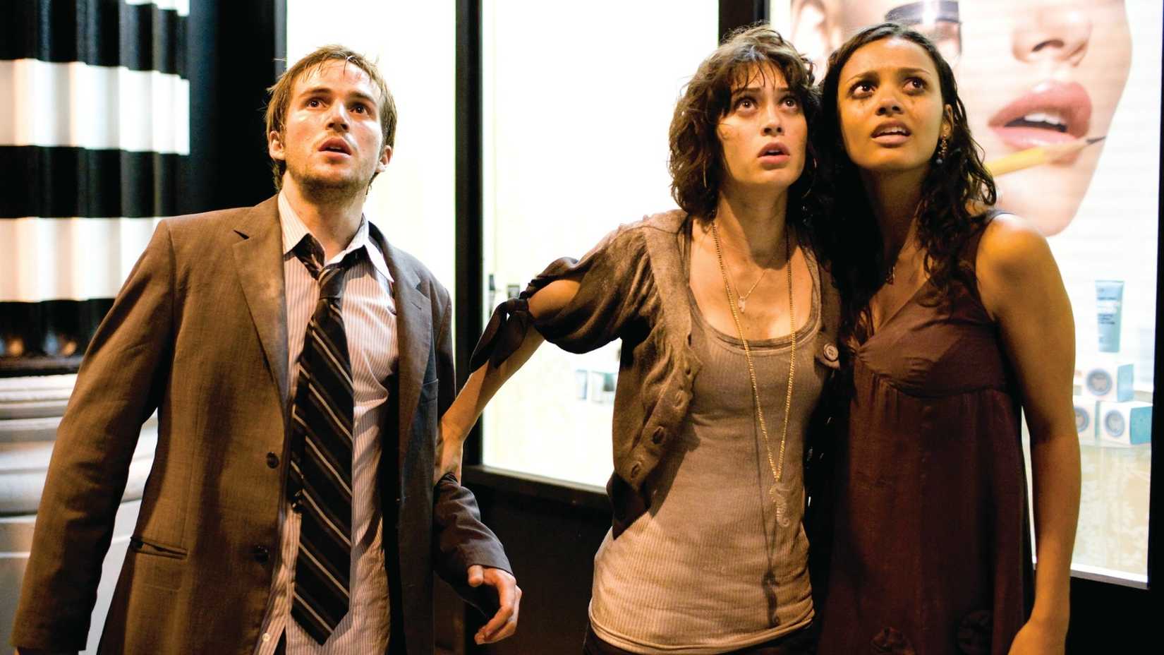 Three people look up in fear in Cloverfield
