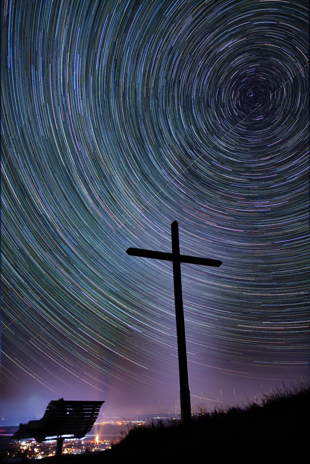 Star trails behind a cross
