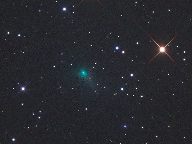 Sungrazing comet: A blueish comet among a field of stars, including one reddish star.