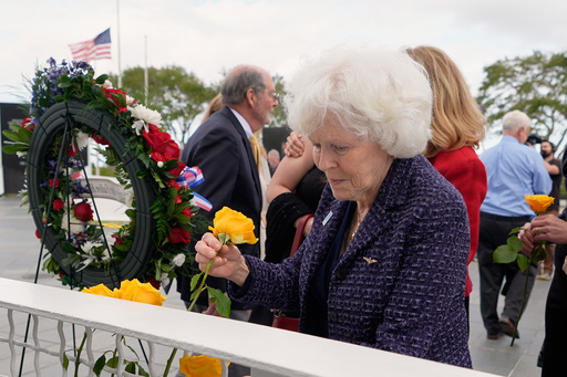 NASA and families of fallen astronauts mark 40th anniversary of space shuttle Challenger accident Jane Smith-Wolcott, center, widow of Challenger pilot Michael Smith puts a flower on a memorial during NASA