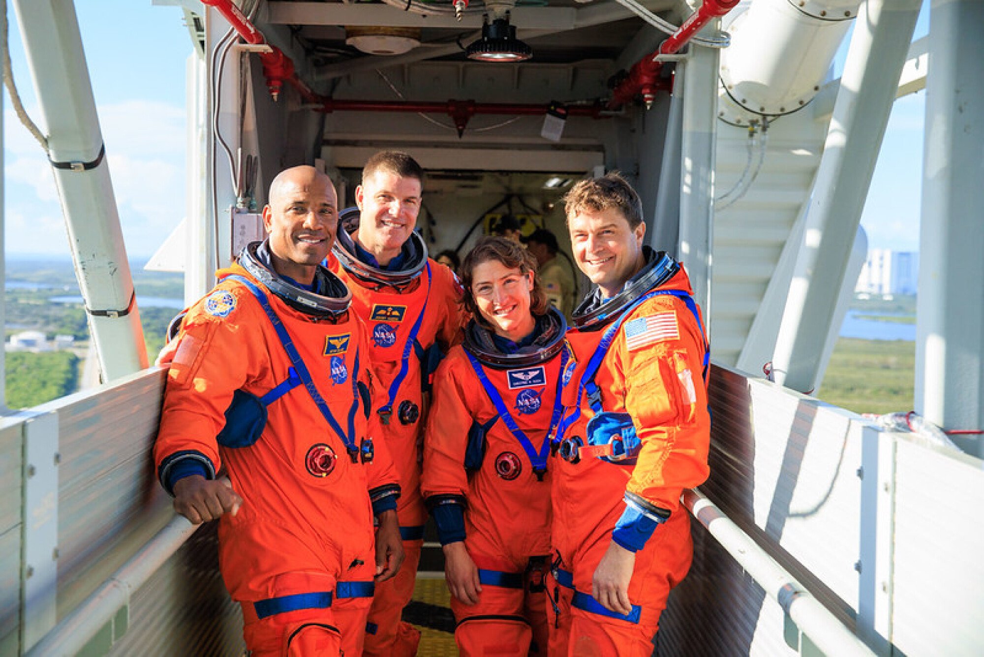 Artemis 2 astronauts standing on the crew access arm of the launcher