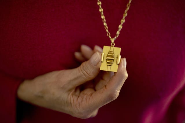 A Holocaust survivor holds her grandmother's necklace