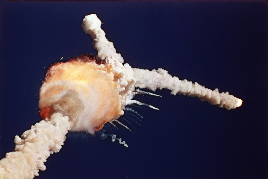 A forked white cloud against a dark blue sky, with a fiery orange ball at the join of the fork.