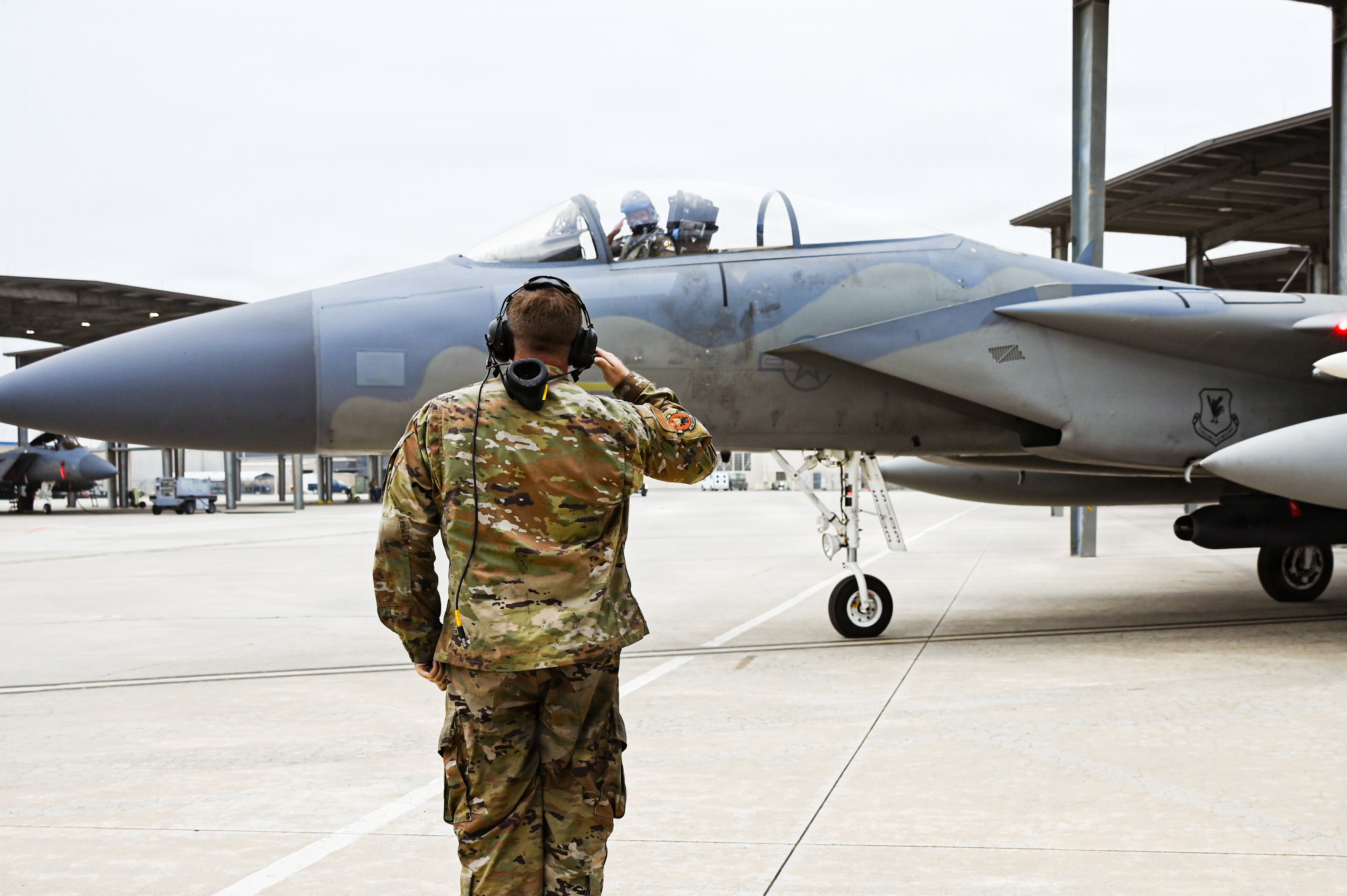 U.S. Air Force Senior Airman Michael Schiefer renders a salute as an F-15C Eagle taxies off the flightline in preparation for a morning launch from the Fresno Air National Guard Base, California, Dec. 2, 2025. The 144th Fighter Wing regularly conducts routine training flights as part of the Ready Aircrew Program. (U.S. Air National Guard Photo by TSgt Julian Castaneda)