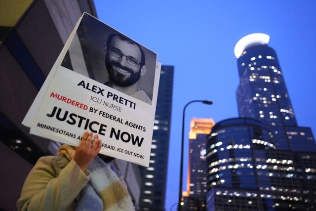 A person holds a sign of Alex Pretti during a protest 