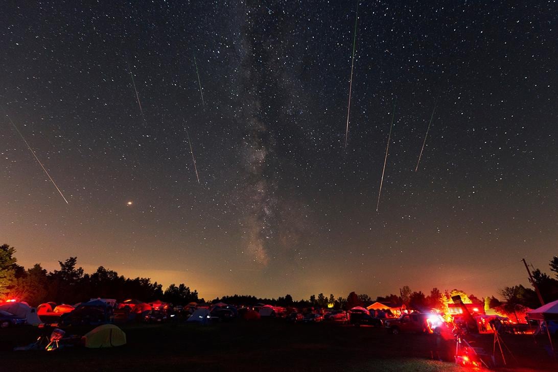 Stars are seen in the sky along with several streaks of light from meteors.