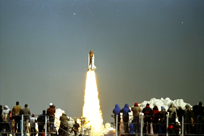 Rocket taking off with a trail of fire underneath it. 