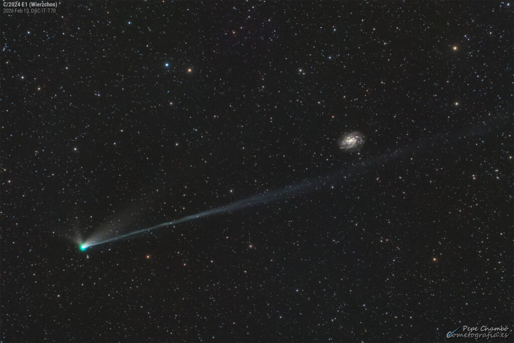 A star field shows a bright comet with its head
on the lower left and tails extending toward the upper
right. A background galaxy is visible on the far right.
Please see the explanation for more detailed information.