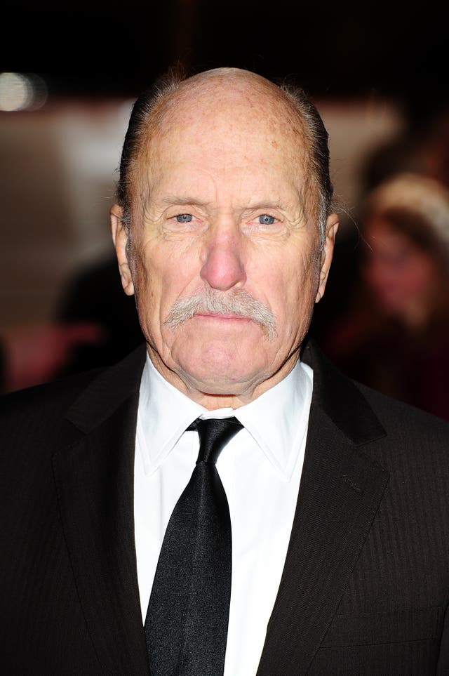 A head and shoulders image of Robert Duvall wearing a white shirt and a black tie and suit