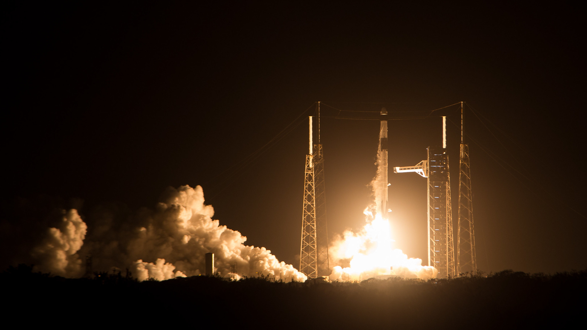 a black and white rocket launches into a dark night sky