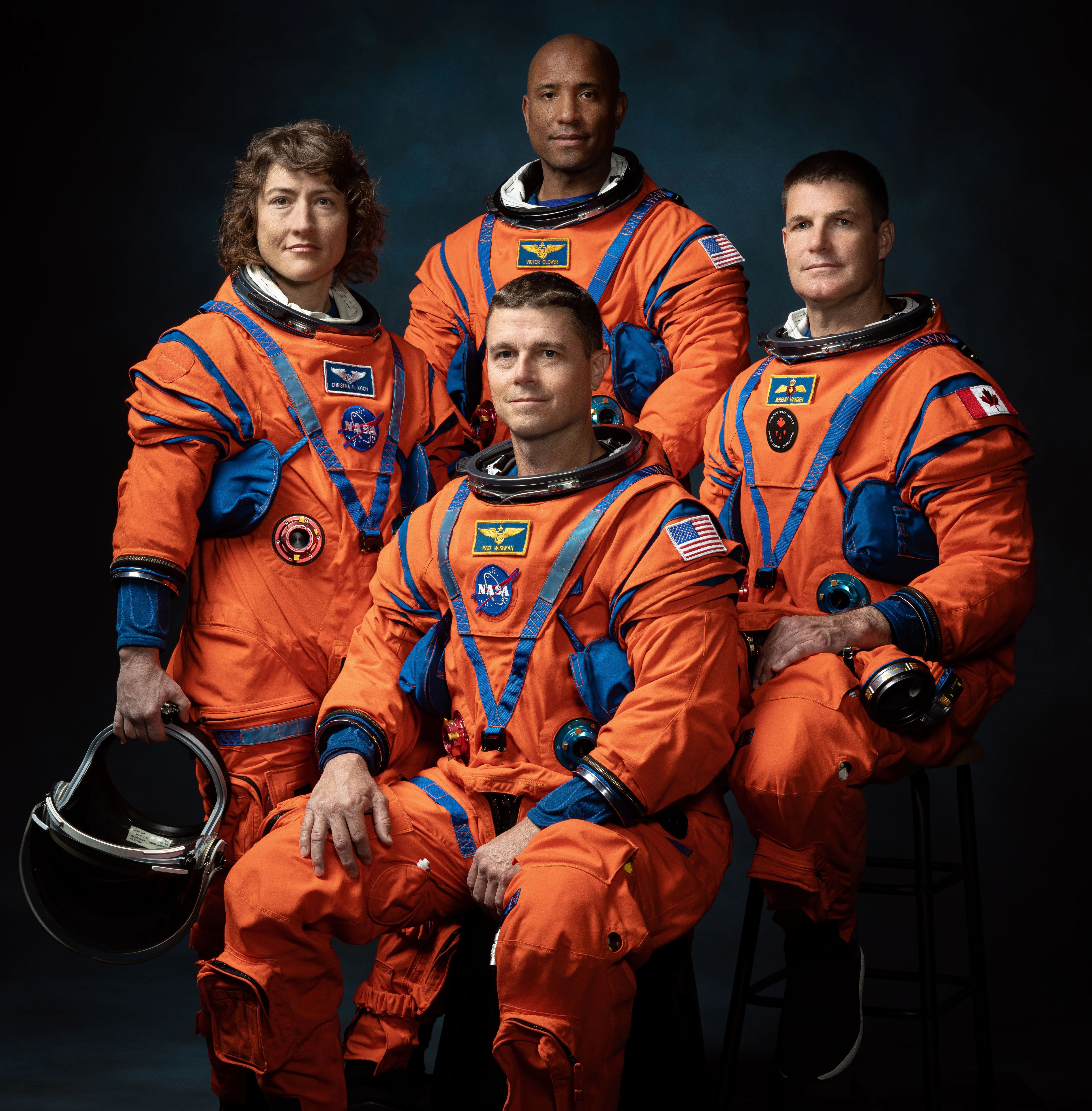 The four crew members of NASA's Artemis II mission, Christina Koch, Reid Wiseman, Victor Glover, and Jeremy Hansen, wearing orange flight suits.