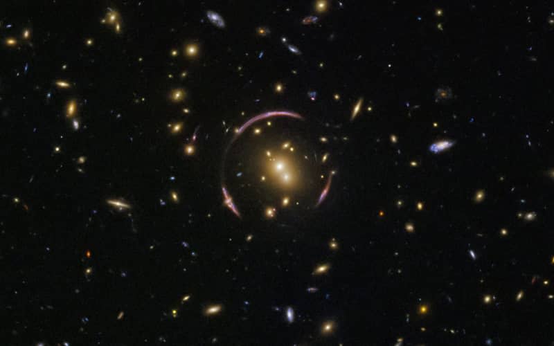 Weak lensing measures tiny distortions in the light from distant galaxies. Pictured above is an Einstein Ring, a glowing circle of light formed by gravitational lensing. (CREDIT: Nature)