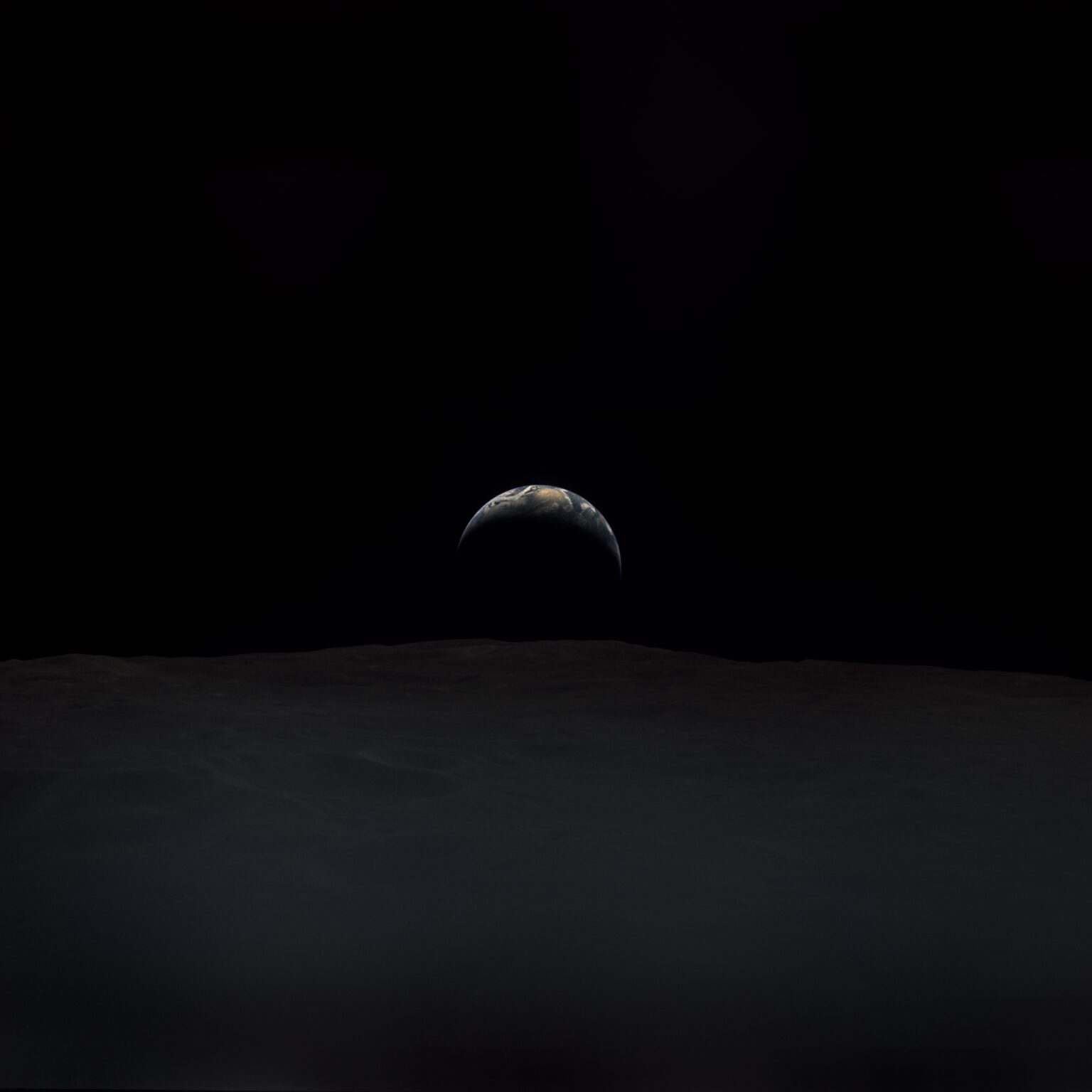 A glinting Earthrise photographed by NASA Astronaut Richard Gordon from the Apollo 12 Command Module during lunar orbit in November 1969