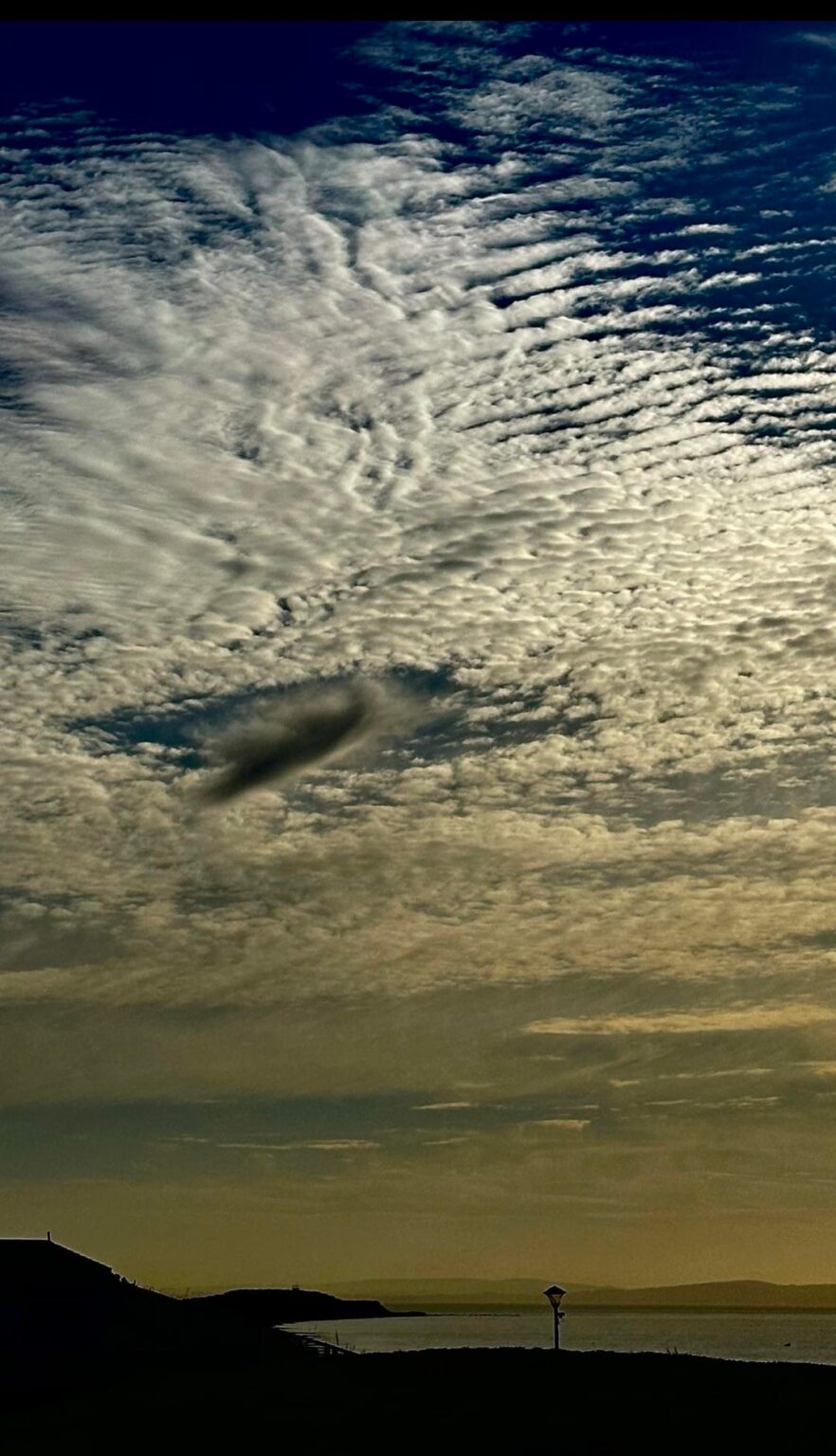 Thoughts please - what is this I photographed? Evidence of something having been there & punched a hole in a cloud? Or still there & cloaked?