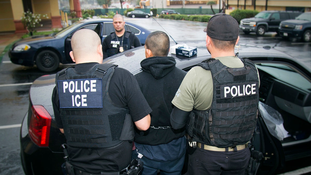 ICE agents arresting a man