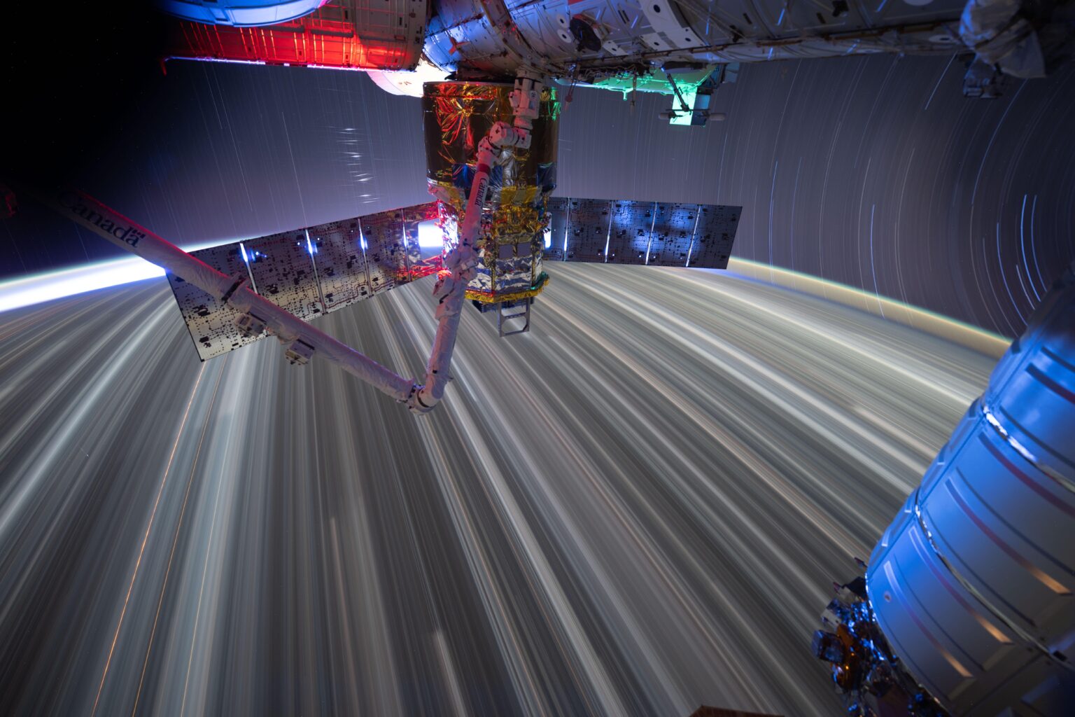 Star trails and city lights streak by in this long-duration photograph from the International Space Station