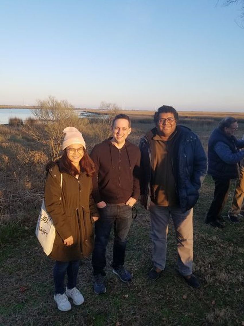 Three people pose for a photograph.