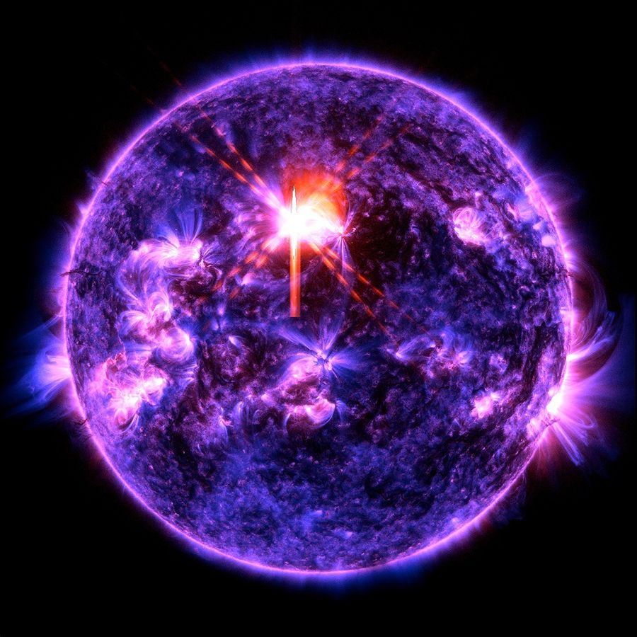 The Sun is blue, purple, and black with a bright purple line surrounding it. Scattered across it are some brighter purple spots where there is higher activity. Just above center is a bright red and white X: This is the solar flare.