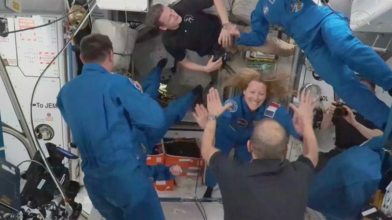 The new astronauts dressed in blue greet the crew members already on the space station. Pic: NASA/AP