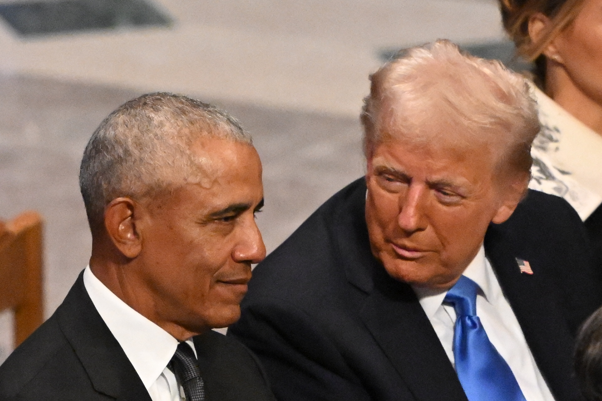 Former President Barack Obama and President-elect Donald Trump speaking to each other at a state funeral.
