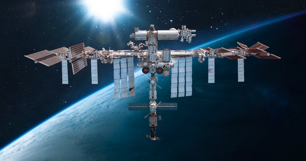 A rendering of the International Space Station with Earth seen behind it.
