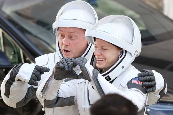 US-SPACE-NASA-CREW-11-SPACEX (L/R) Crew-11 mission members NASA astronaut Mike Fincke and NASA astronaut and mission commander Zena Cardman gesture to family and supporters as they depart the Neil A. Armstrong Operations and Checkout Building en route to launch complex LC-39A at the Kennedy Space Center in Cape Canaveral, Florida on August 1, 2025. (Photo by Gregg Newton / AFP) (Photo by GREGG NEWTON/AFP via Getty Images)