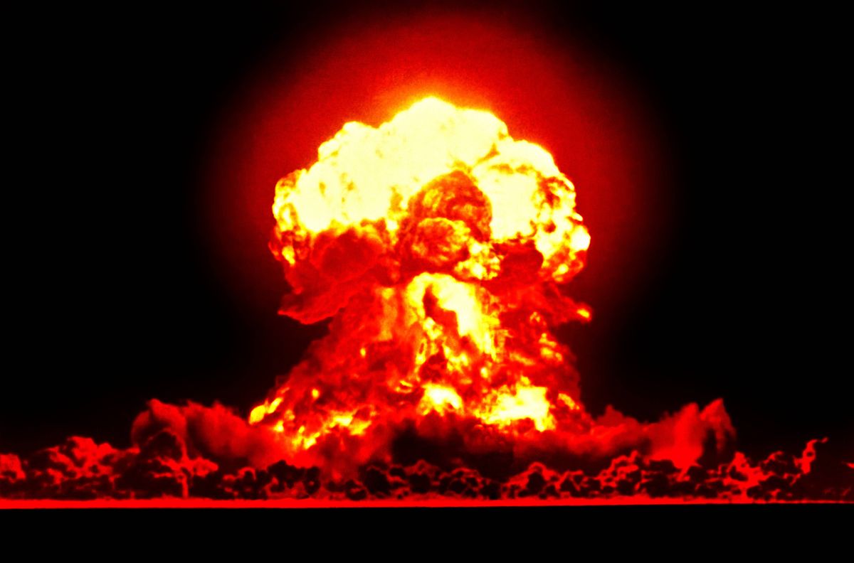 An intense and dramatic nuclear explosion depicted in vivid colors of red and yellow against a dark background, illustrating the formidable power and energy release of such an event.