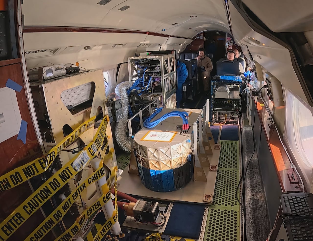 A small enclosed space with yellow caution tape and other items, with people onboard. 