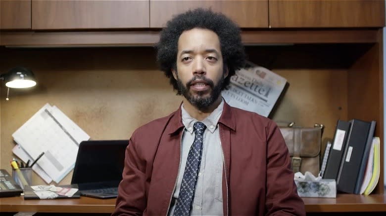 Ozzie frowning and sitting at a desk in "People of Earth."