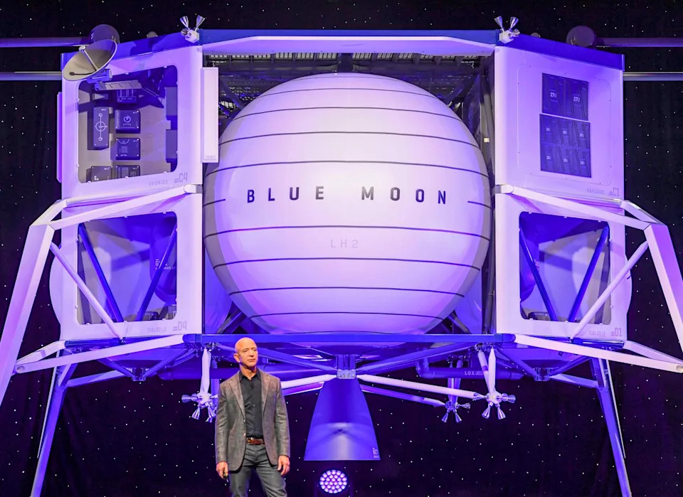 Jeff Bezos stands in front of a large spacecraft lander labeled 'Blue Moon'