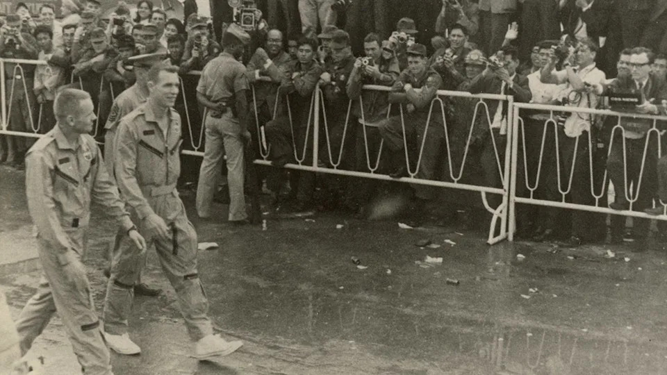 Neil Armstrong and astronaut David Scott walking by service members